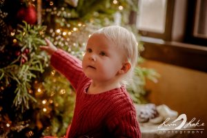 Child in front of Christmas tree in the living room of the Kellogg Manor House