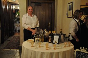 Host with a table of wine glasses for guests